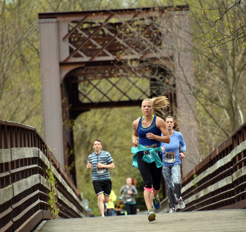 Runners cross over the railroad bridge into Collinsville.